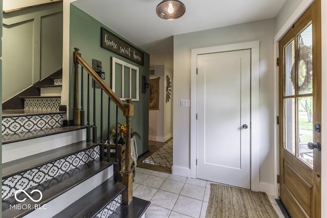 foyer featuring stairway, baseboards, and plenty of natural light