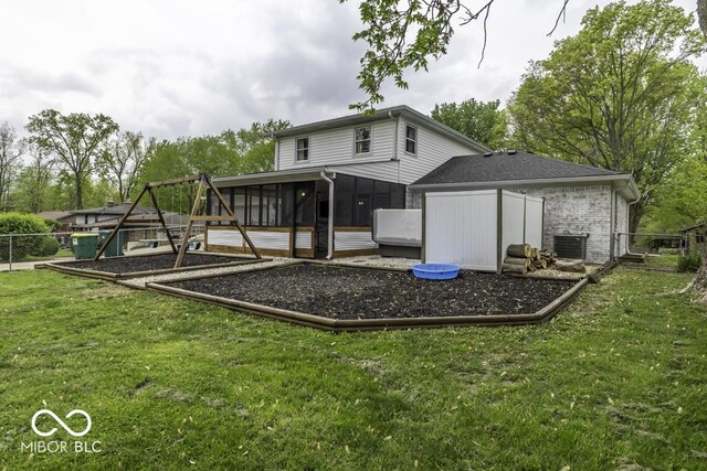back of house featuring a lawn, a playground, a sunroom, and fence