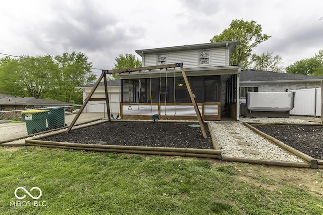 rear view of property featuring a sunroom and fence