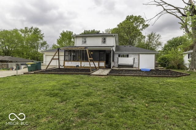 back of property with a yard, a sunroom, an attached garage, and fence