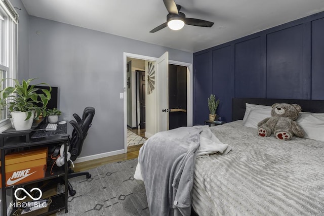 bedroom with ceiling fan, baseboards, and wood finished floors