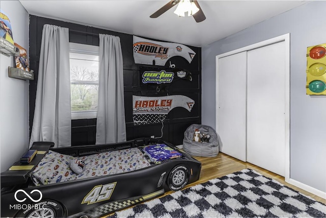 bedroom featuring a closet, wood finished floors, and a ceiling fan