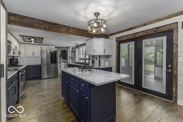 kitchen with dark wood finished floors, white cabinets, appliances with stainless steel finishes, and blue cabinetry