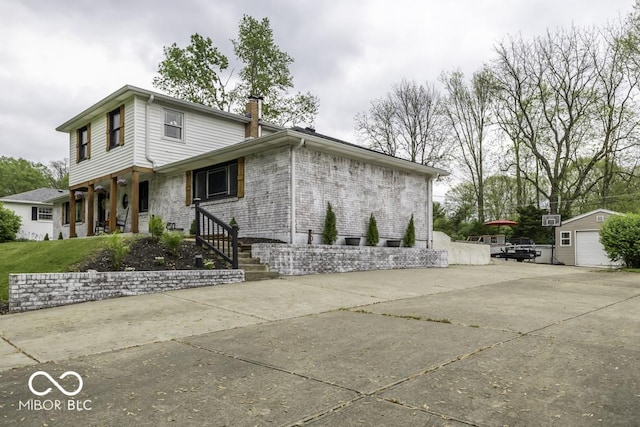 view of home's exterior featuring brick siding, a chimney, and an outbuilding