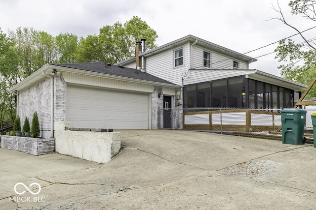 view of front facade with concrete driveway, brick siding, a sunroom, and a garage