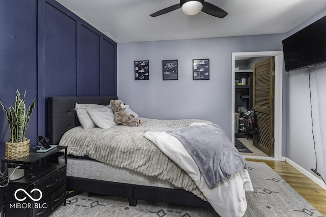 bedroom featuring ceiling fan, baseboards, and light wood-type flooring