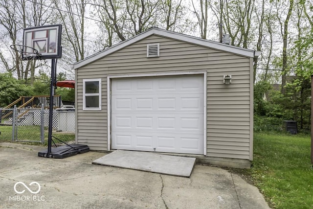 detached garage featuring driveway and fence
