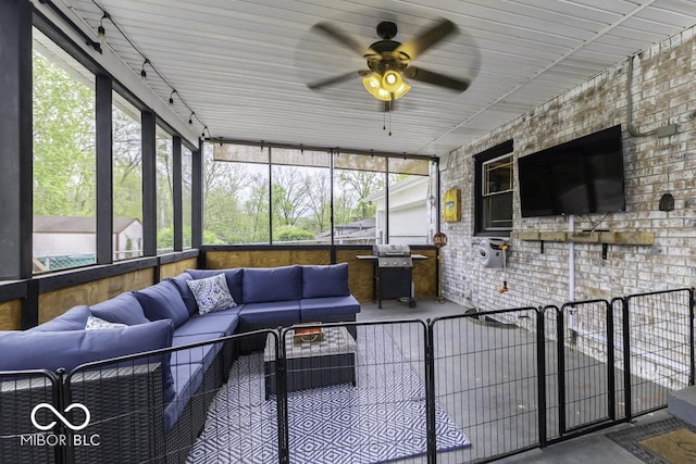 sunroom / solarium featuring ceiling fan and an outdoor living space