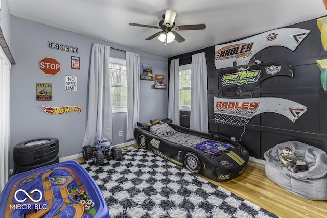 bedroom featuring wood finished floors, baseboards, and ceiling fan