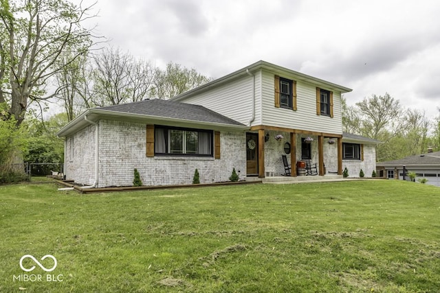view of front of property with a front yard, a porch, and brick siding