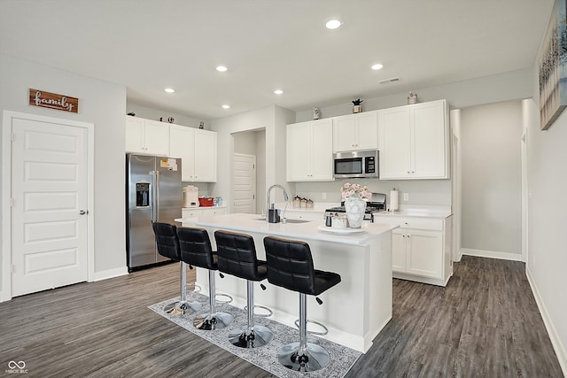 kitchen with baseboards, stainless steel appliances, white cabinets, and a sink