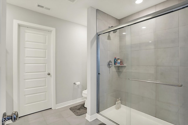 full bathroom with toilet, visible vents, baseboards, and a shower stall
