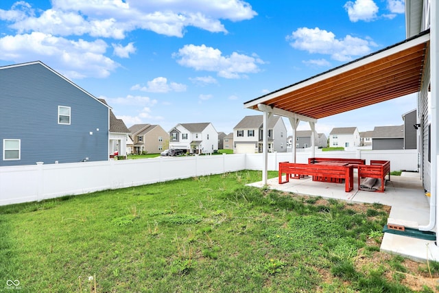 view of yard featuring a patio, a residential view, and fence