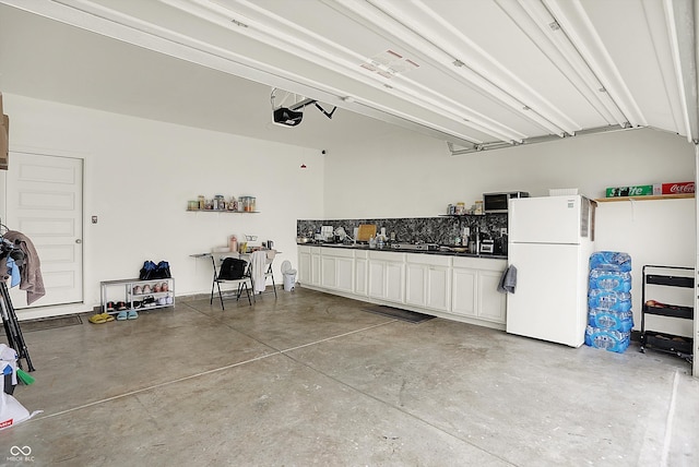 garage with freestanding refrigerator and a garage door opener