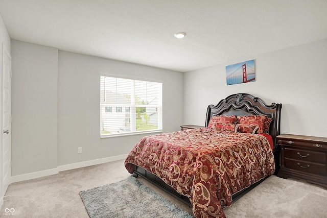 bedroom with baseboards and light carpet