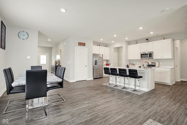 kitchen with dark wood-style flooring, baseboards, white cabinets, and appliances with stainless steel finishes