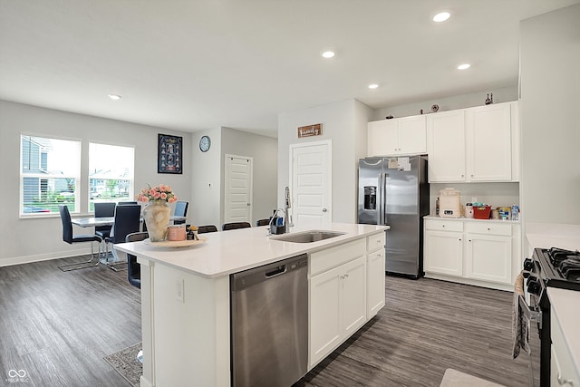 kitchen with dark wood finished floors, appliances with stainless steel finishes, white cabinets, and a sink