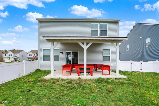 rear view of house featuring a yard, a patio area, and a fenced backyard