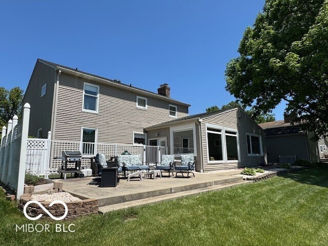 rear view of house featuring a chimney and a patio