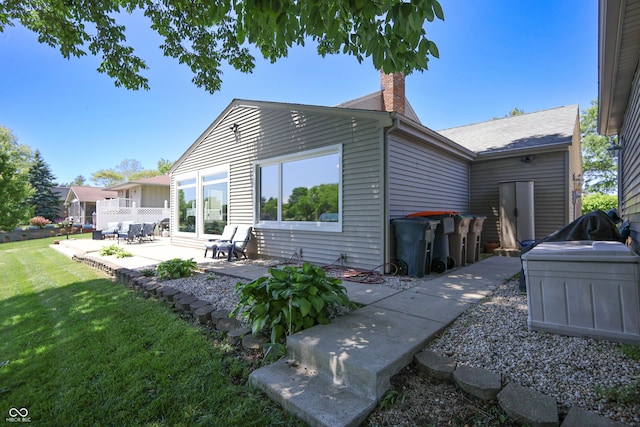 3829 Waycross Dr, Columbus, IN 47203 - back of property featuring a patio, a lawn, and a chimney