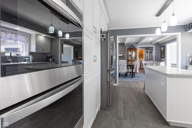 3829 Waycross Dr, Columbus, IN 47203 - kitchen with freestanding refrigerator, dark wood finished floors, decorative light fixtures, white cabinets, and beamed ceiling