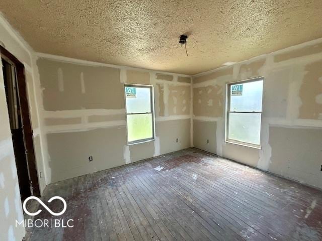 2701 N Gale St, Indianapolis, IN 46218 - spare room with a textured ceiling and hardwood / wood-style flooring