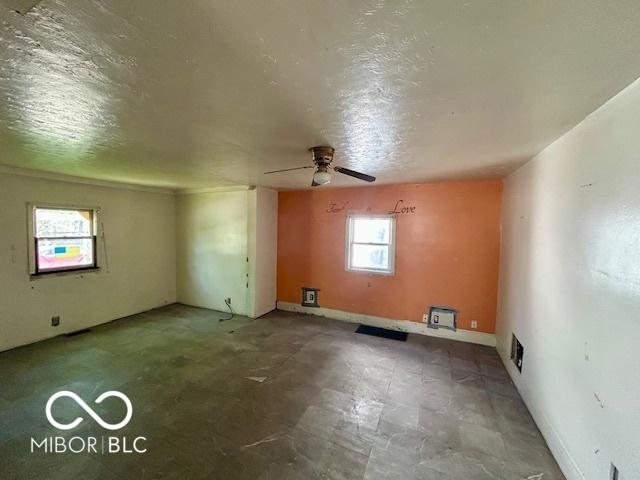 2701 N Gale St, Indianapolis, IN 46218 - spare room featuring a ceiling fan, baseboards, visible vents, and a textured ceiling