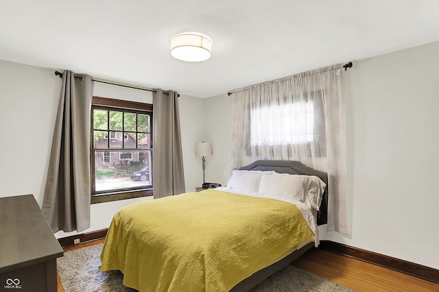 bedroom with dark wood-style floors and baseboards