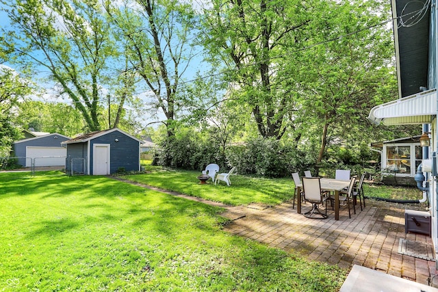 view of yard with a patio area, an outbuilding, a shed, a garage, and view of scattered trees