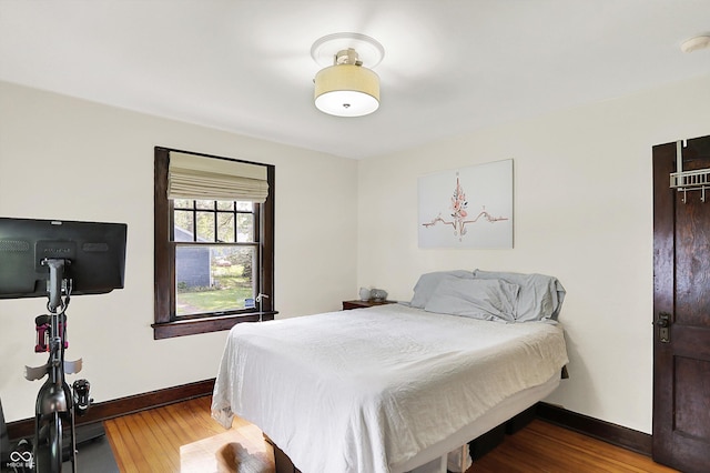 bedroom featuring baseboards and wood finished floors