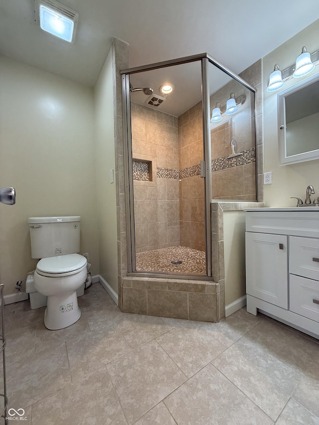 bathroom featuring toilet, a shower stall, tile patterned floors, vanity, and baseboards