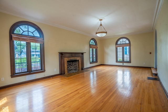 unfurnished living room featuring light wood finished floors, ornamental molding, a fireplace, and baseboards