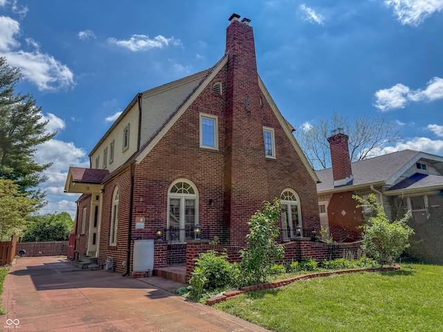 view of front of home featuring a chimney, brick siding, and a shingled roof