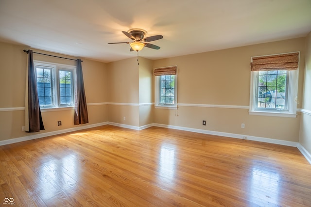 unfurnished room with plenty of natural light, a ceiling fan, and light wood-type flooring