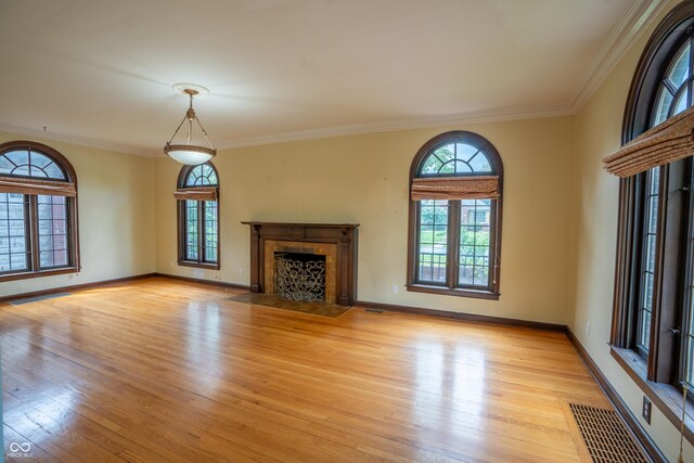 unfurnished living room featuring light wood-style flooring, a fireplace with flush hearth, ornamental molding, and baseboards