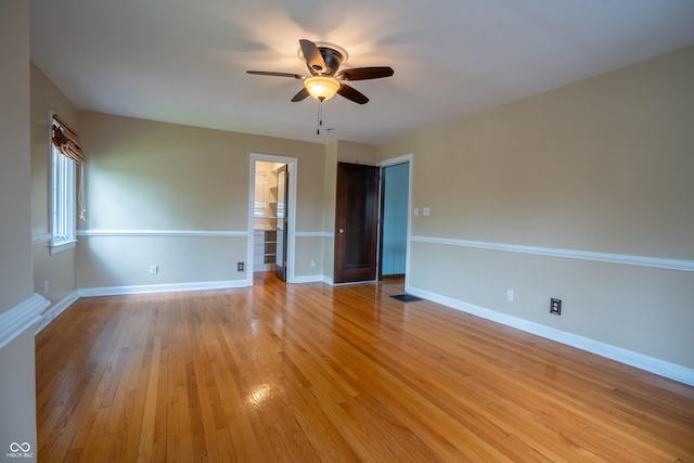 unfurnished room with a ceiling fan, light wood finished floors, and baseboards