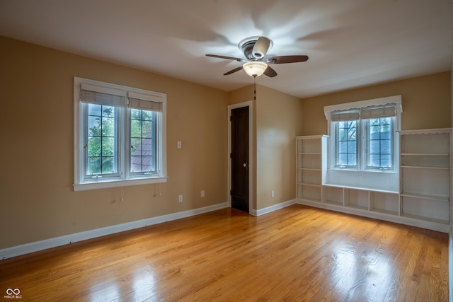 unfurnished room featuring light wood-style flooring, ceiling fan, and baseboards