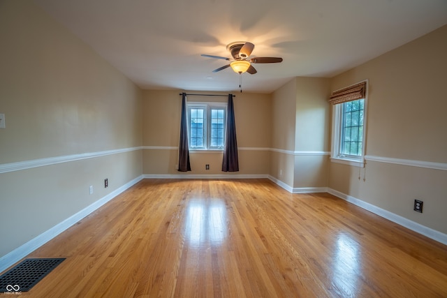 empty room featuring light wood-style floors, ceiling fan, and baseboards