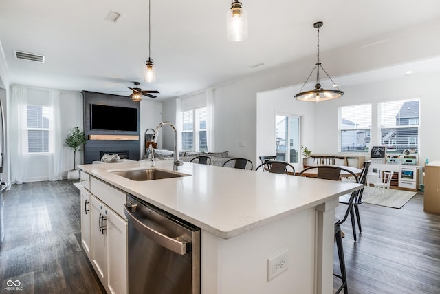 kitchen with a breakfast bar area, a sink, dark wood finished floors, visible vents, and dishwasher