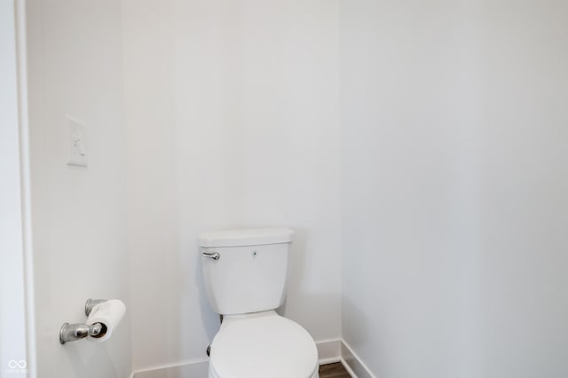 bathroom featuring toilet, baseboards, and wood finished floors