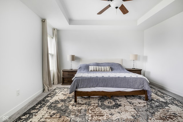 bedroom with baseboards, a raised ceiling, ceiling fan, and carpet floors