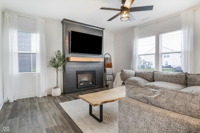 living room featuring baseboards, visible vents, ceiling fan, wood finished floors, and a fireplace