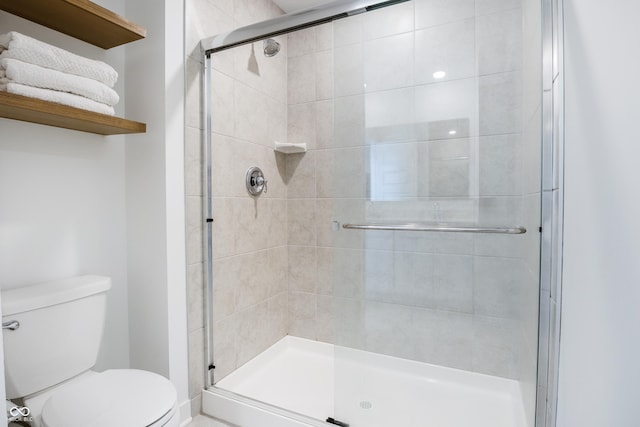 bathroom featuring a stall shower and toilet