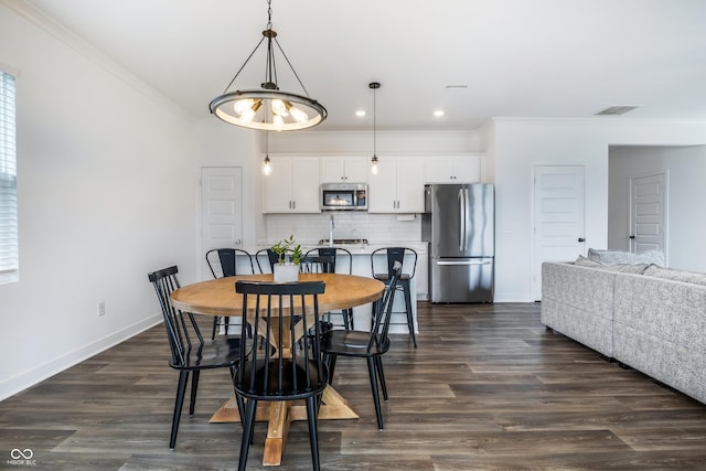 dining area with crown molding, visible vents, dark wood-style flooring, baseboards, and recessed lighting