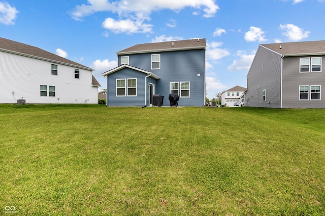 rear view of property featuring a yard and central AC