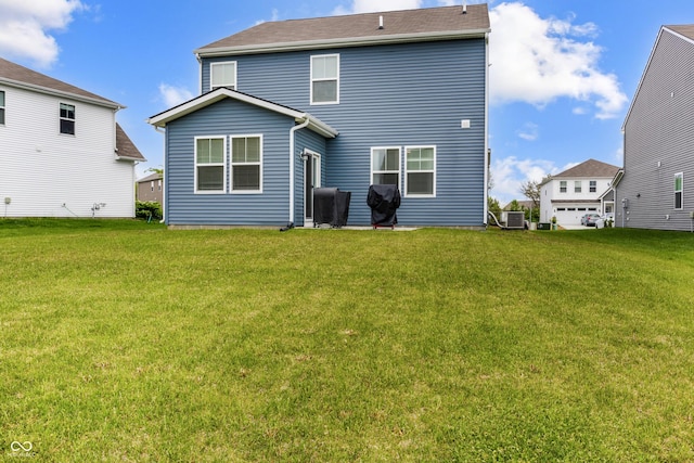 rear view of property with a lawn and central AC unit