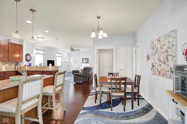 dining space with a ceiling fan, a chandelier, dark wood-style floors, and recessed lighting