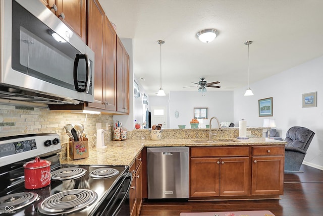 kitchen with stainless steel appliances, a sink, a ceiling fan, a peninsula, and tasteful backsplash