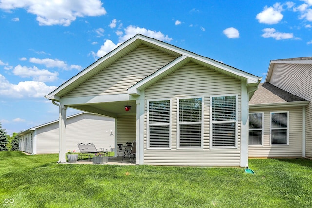 rear view of house with a yard and a patio