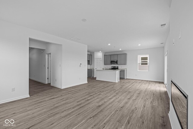 6219 Medina Spirit Dr, Indianapolis, IN 46237 - unfurnished living room featuring light wood finished floors and recessed lighting